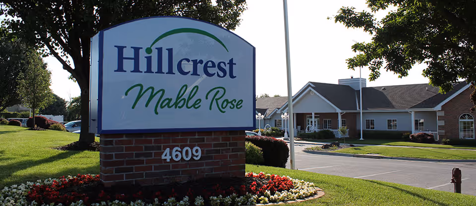 Exterior view of Hillcrest Mable Rose sign and entrance surrounded by manicured landscaping.