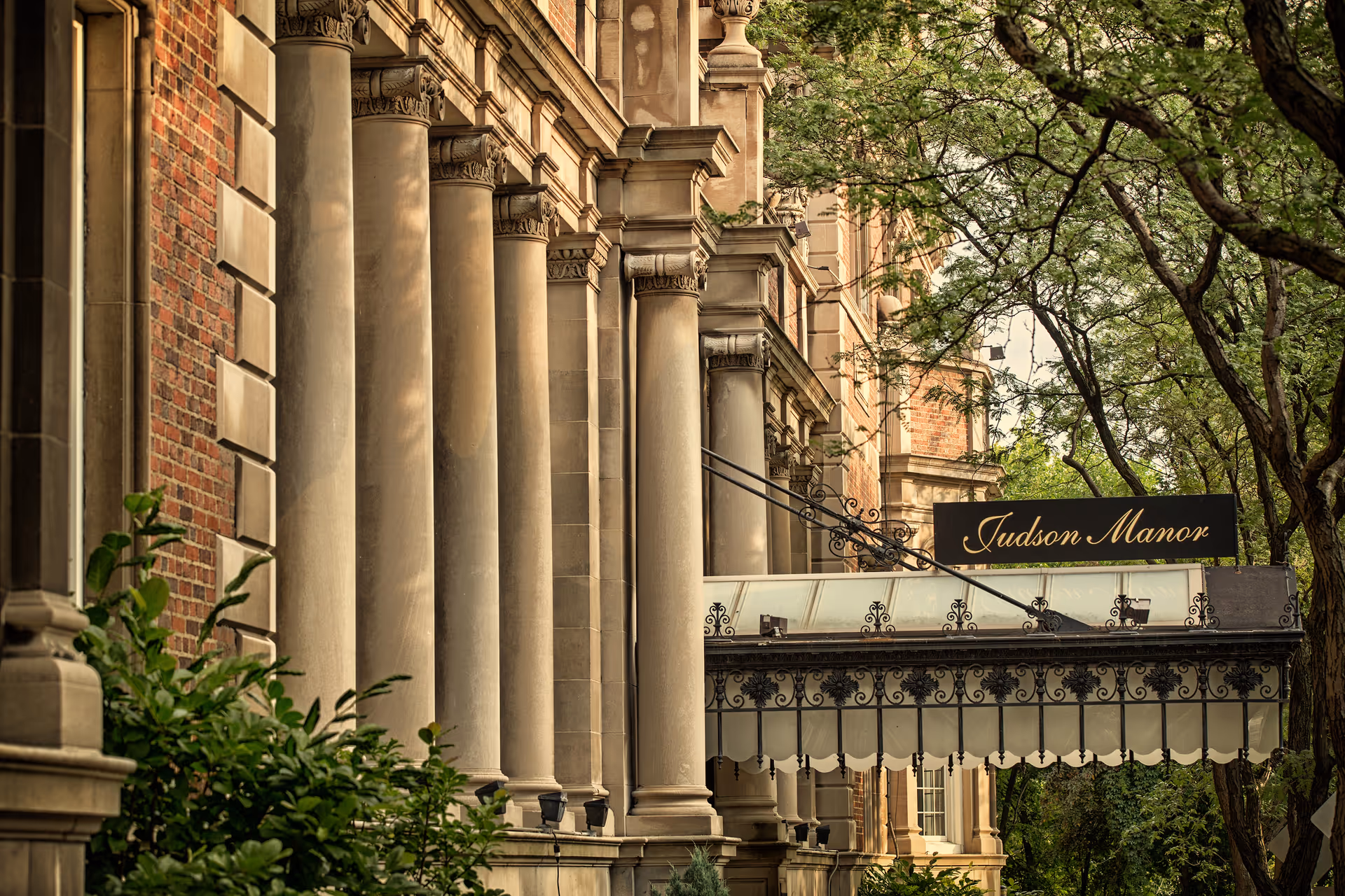 Exterior of Judson Manor with columns, brick facade, and a decorative canopy sign.
