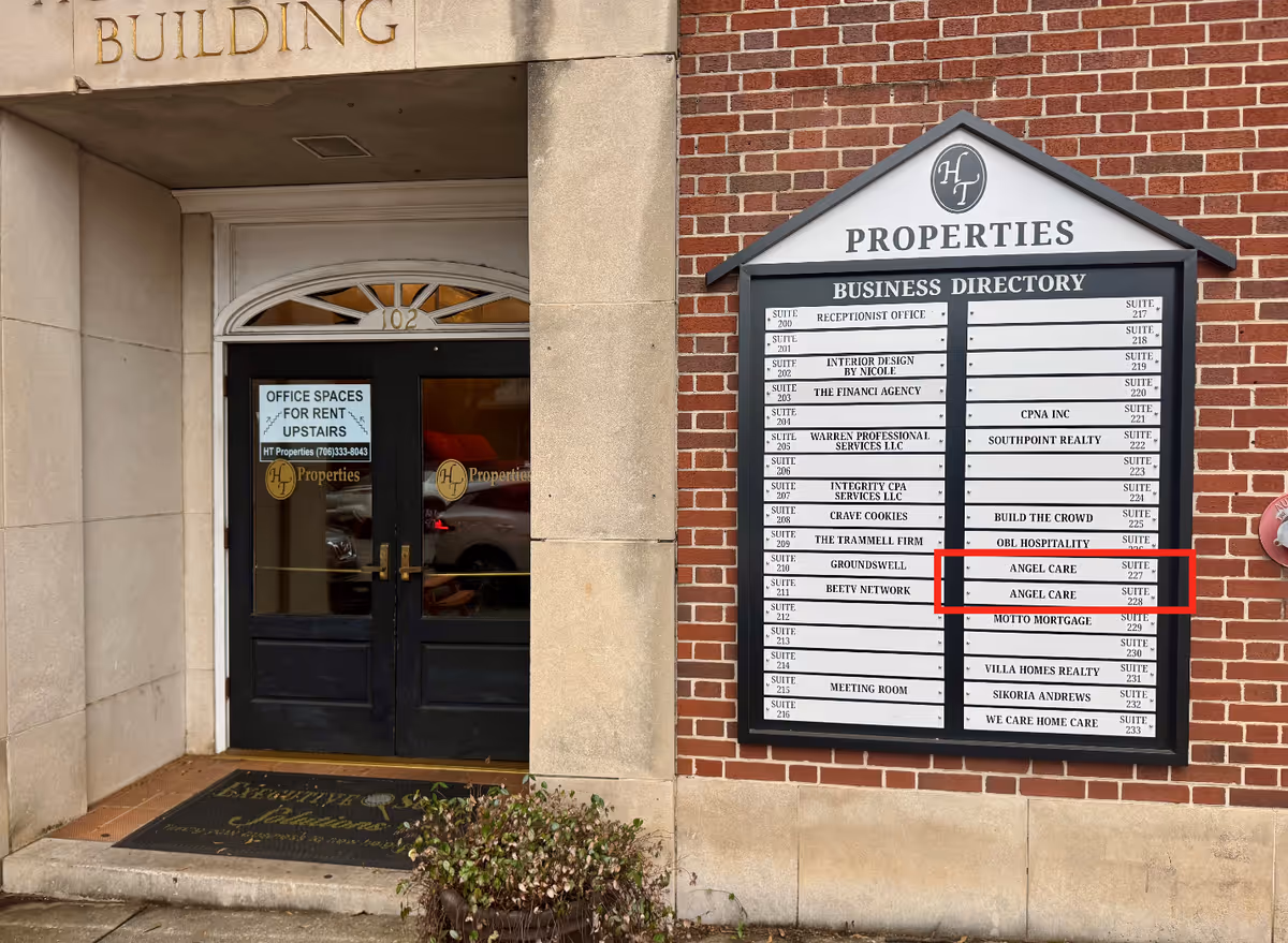 Exterior building entrance with a directory sign listing tenants, including Angel Care.