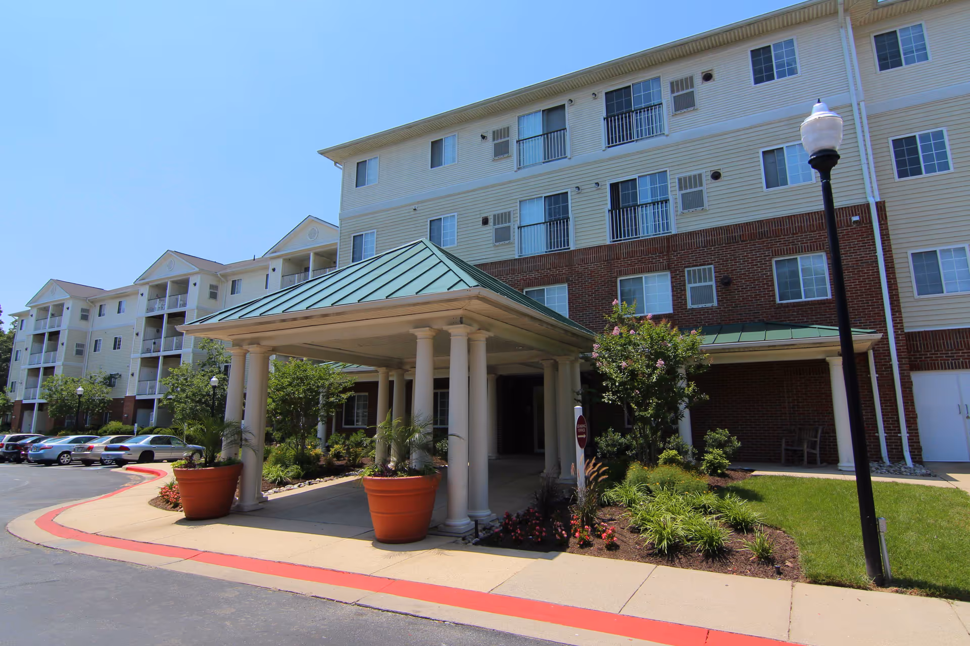 Exterior view of Glen Forest senior living facility with entrance canopy and landscaping.