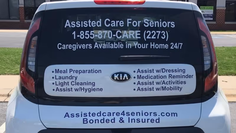 Back of a two-tone van advertising Assisted Care for Seniors and listed services.