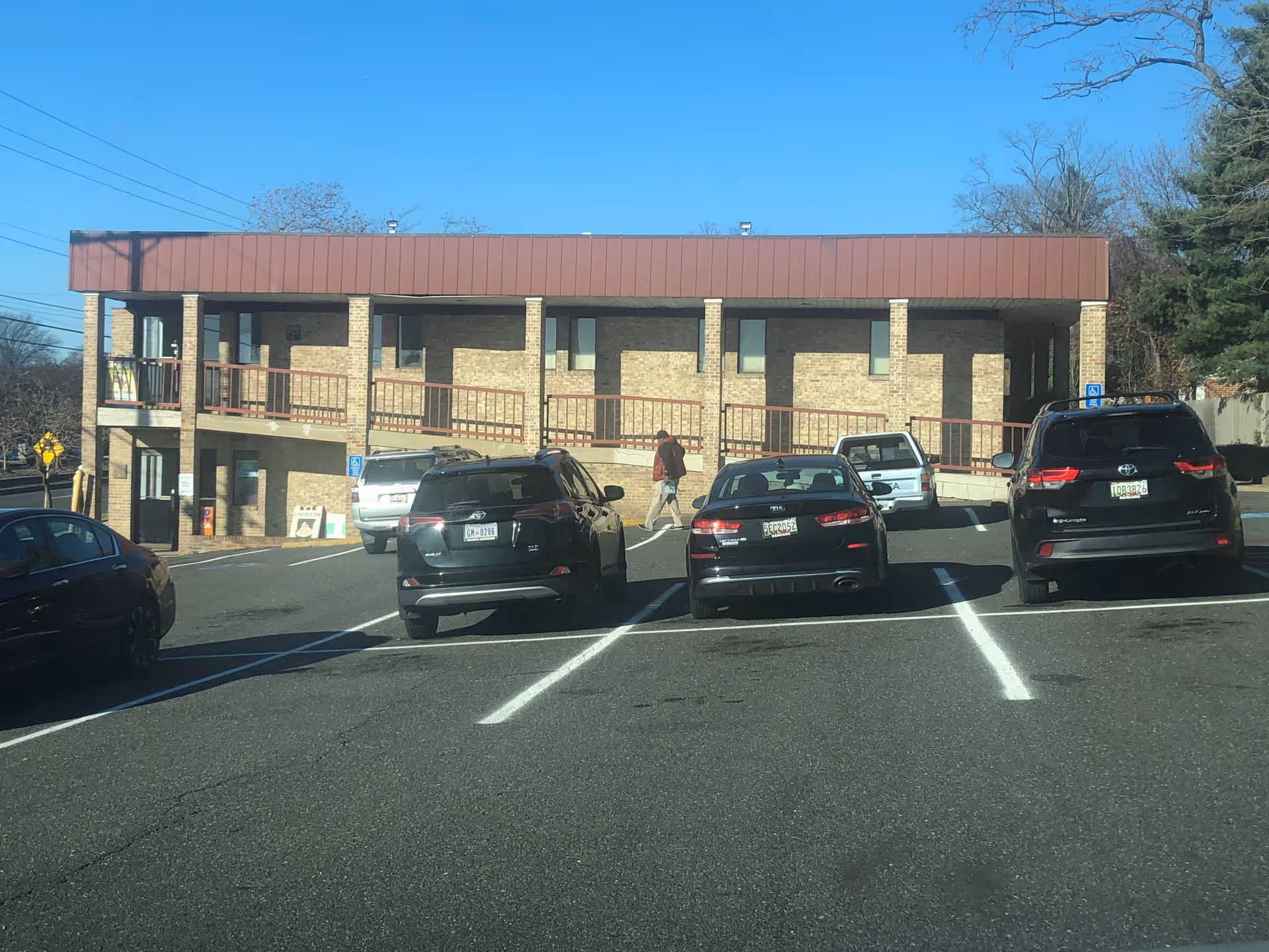 Two-story brick senior living facility with a parking lot and cars in front.