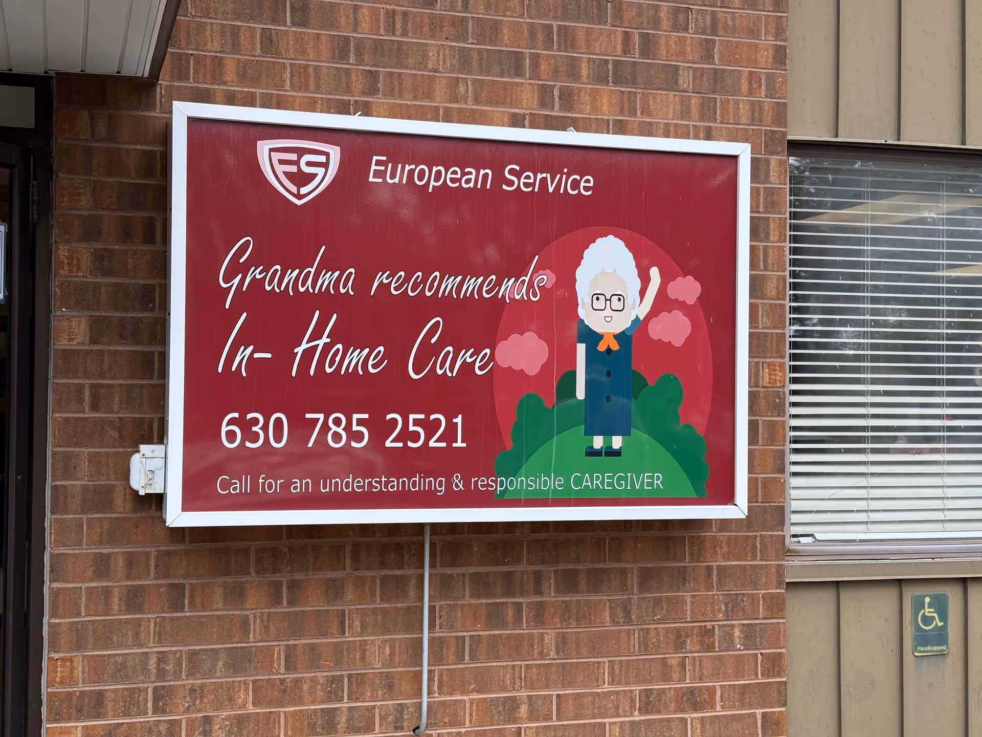 Exterior brick wall with a large red European Service sign advertising in-home care.
