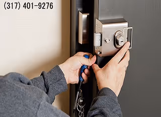 Close-up of hands working on a door lock on an interior door.