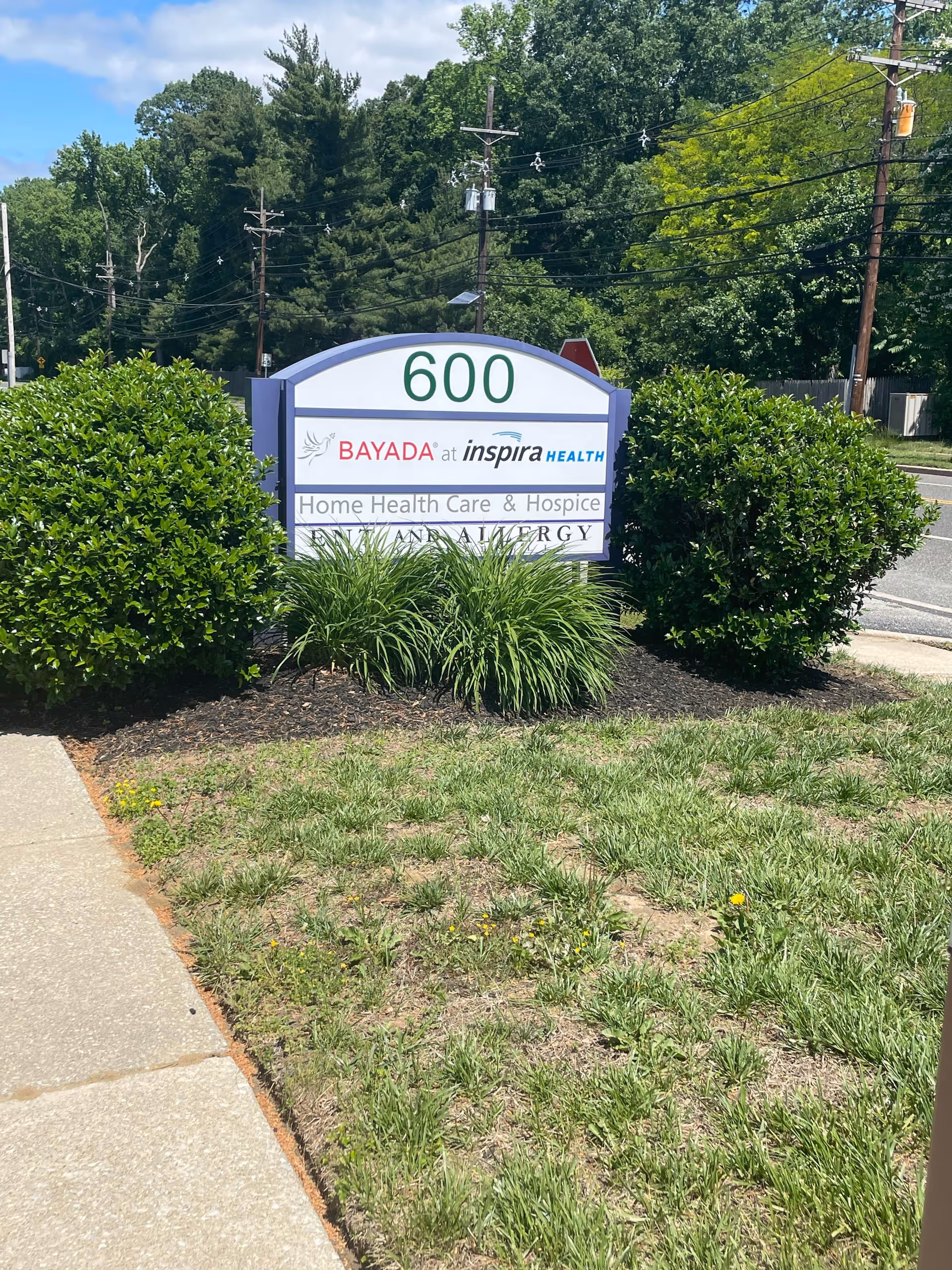 Exterior sign at 600 for BAYADA at Inspira Health, with shrubs.