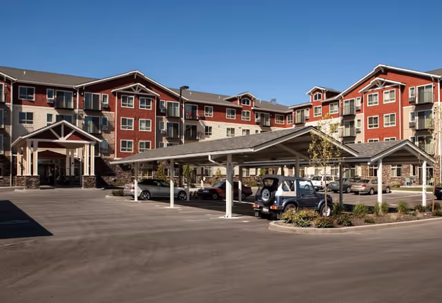 Exterior view of Affinity at Boise senior living complex with cars and covered driveways.