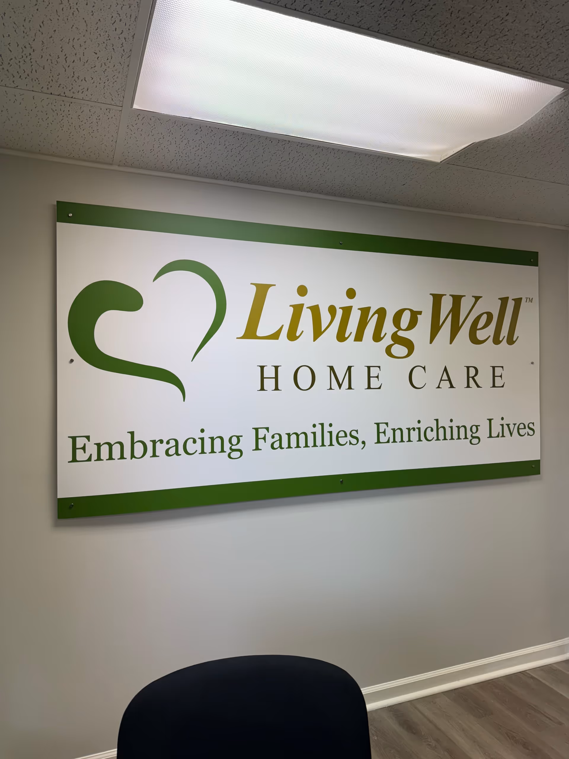 Interior wall featuring a LivingWell Home Care sign and ceiling light.