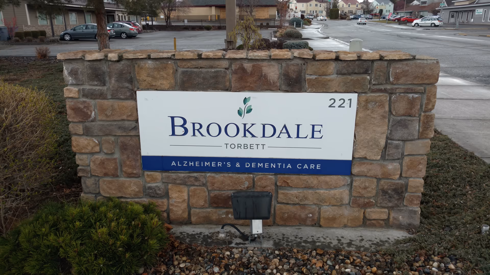 Stone Brookdale Torbett sign mounted on a brick wall in front of a parking lot.
