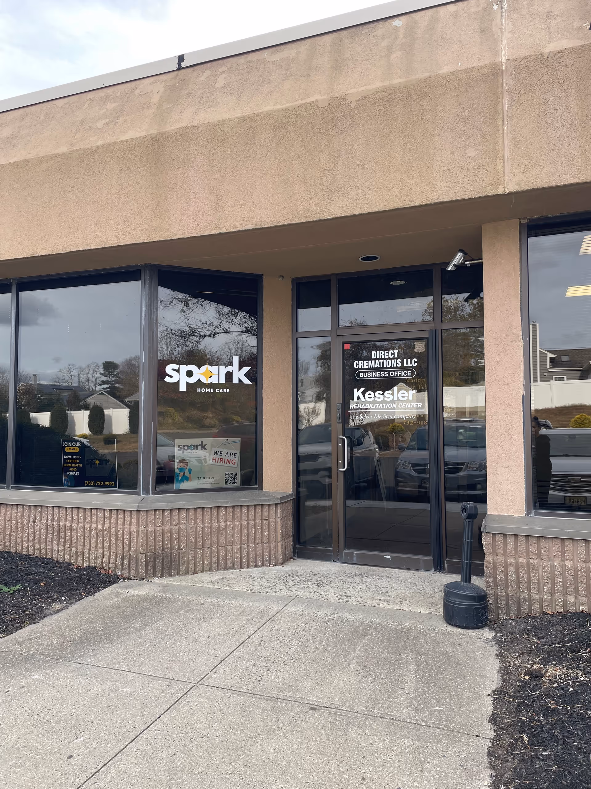 Exterior view of Spark Home Care storefront with glass doors and signage.