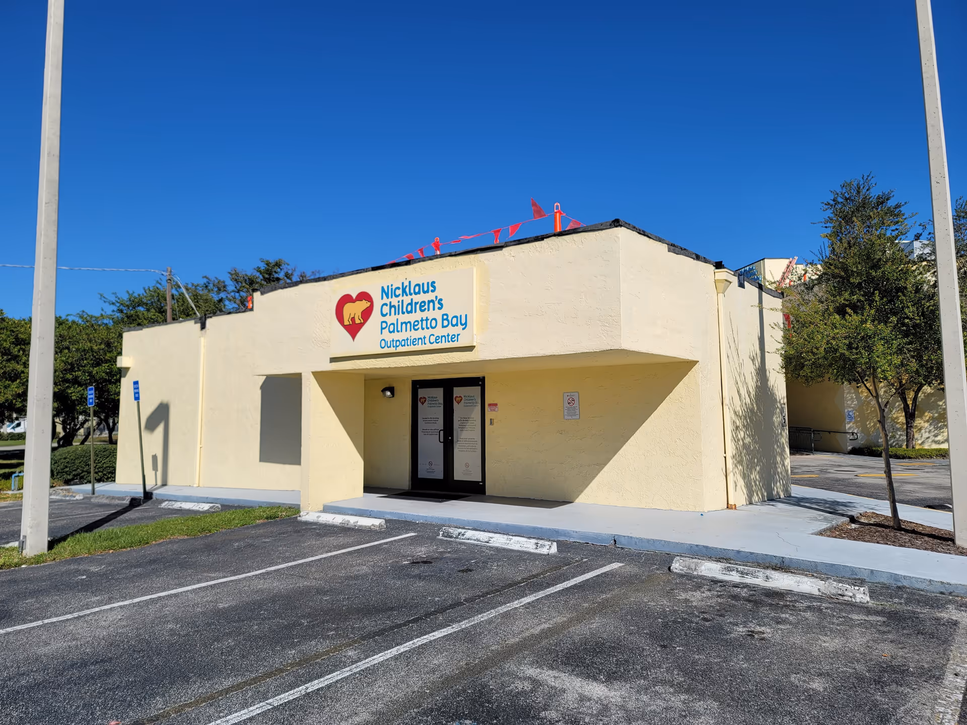 Exterior view of Nicklaus Children's Palmetto Bay Outpatient Center building with sign and parking.