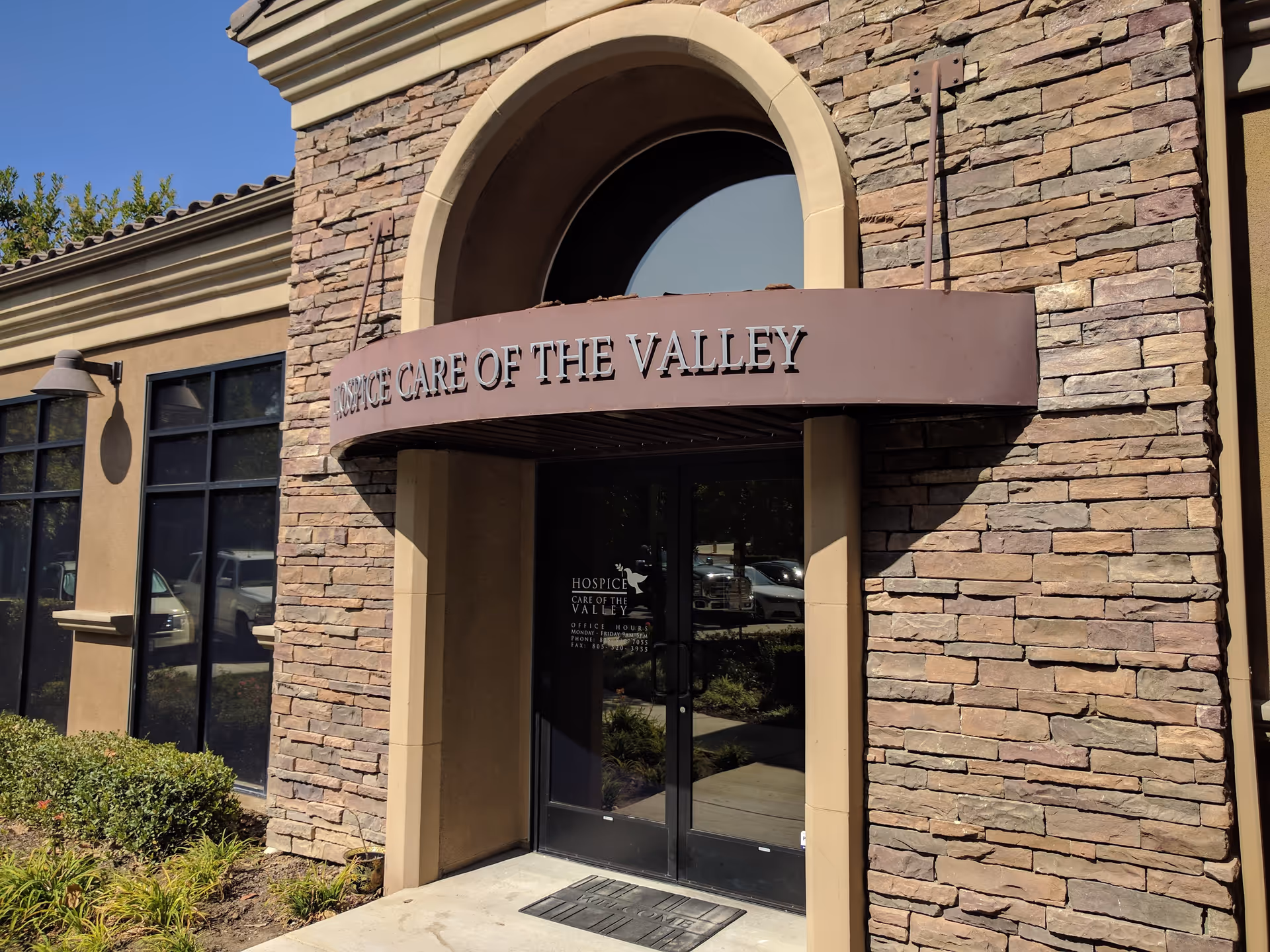 Stone building entrance with arched doorway and Hospice Care of the Valley sign.