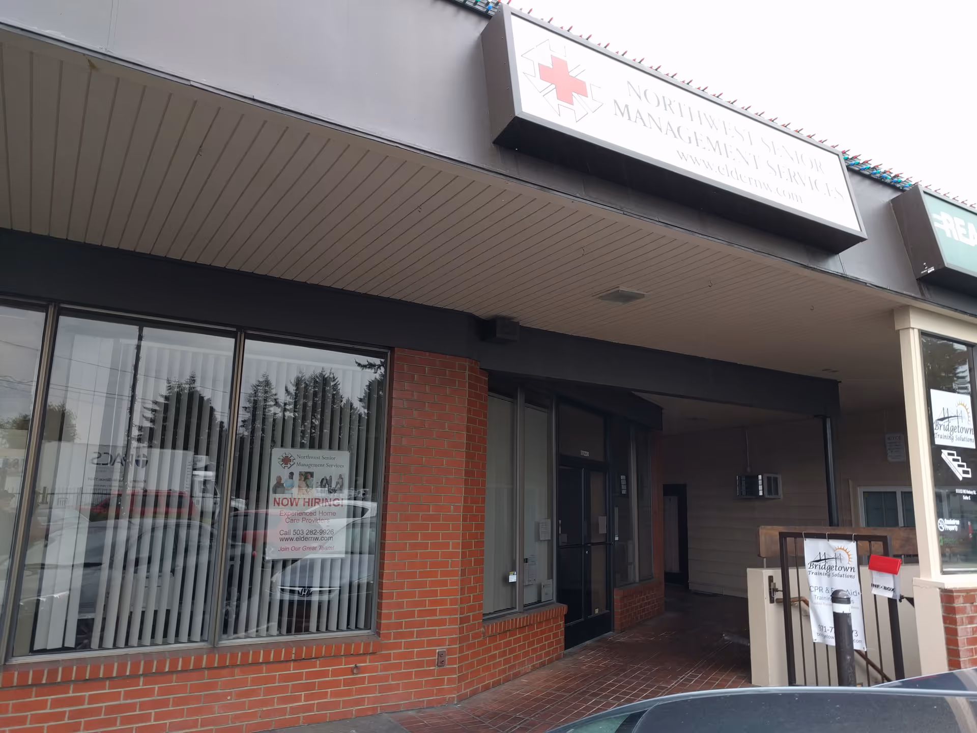 Exterior storefront with brick walls and a Northwest Senior Management sign.