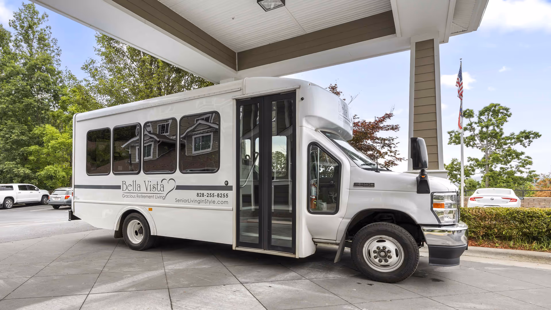 White Bella Vista shuttle bus at the facility entrance under a covered drop-off.