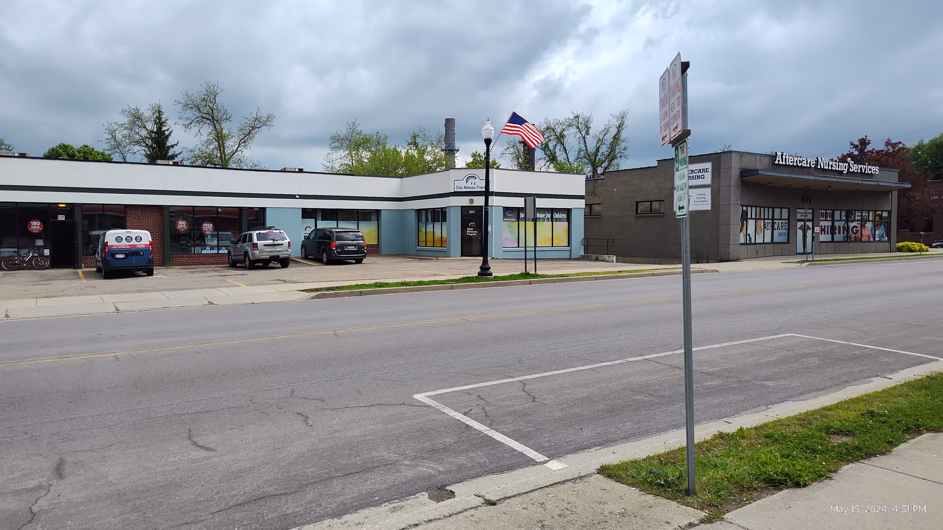 Exterior view of Aftercare Nursing Services building along a street with cars.