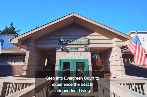 Front view of Evergreen Court senior living facility entrance with American flag.