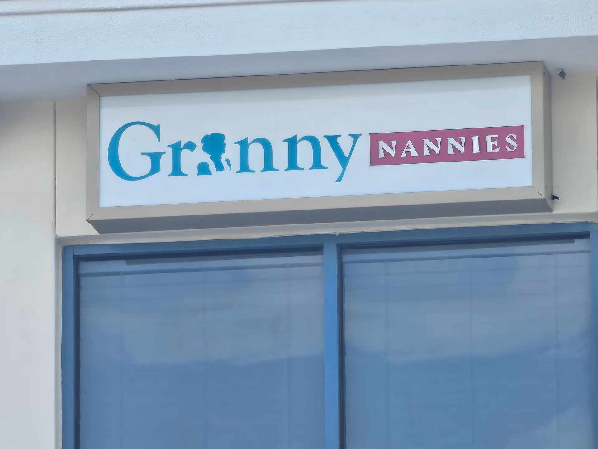 Exterior storefront with a Granny NANNIES sign above blue-framed glass doors.