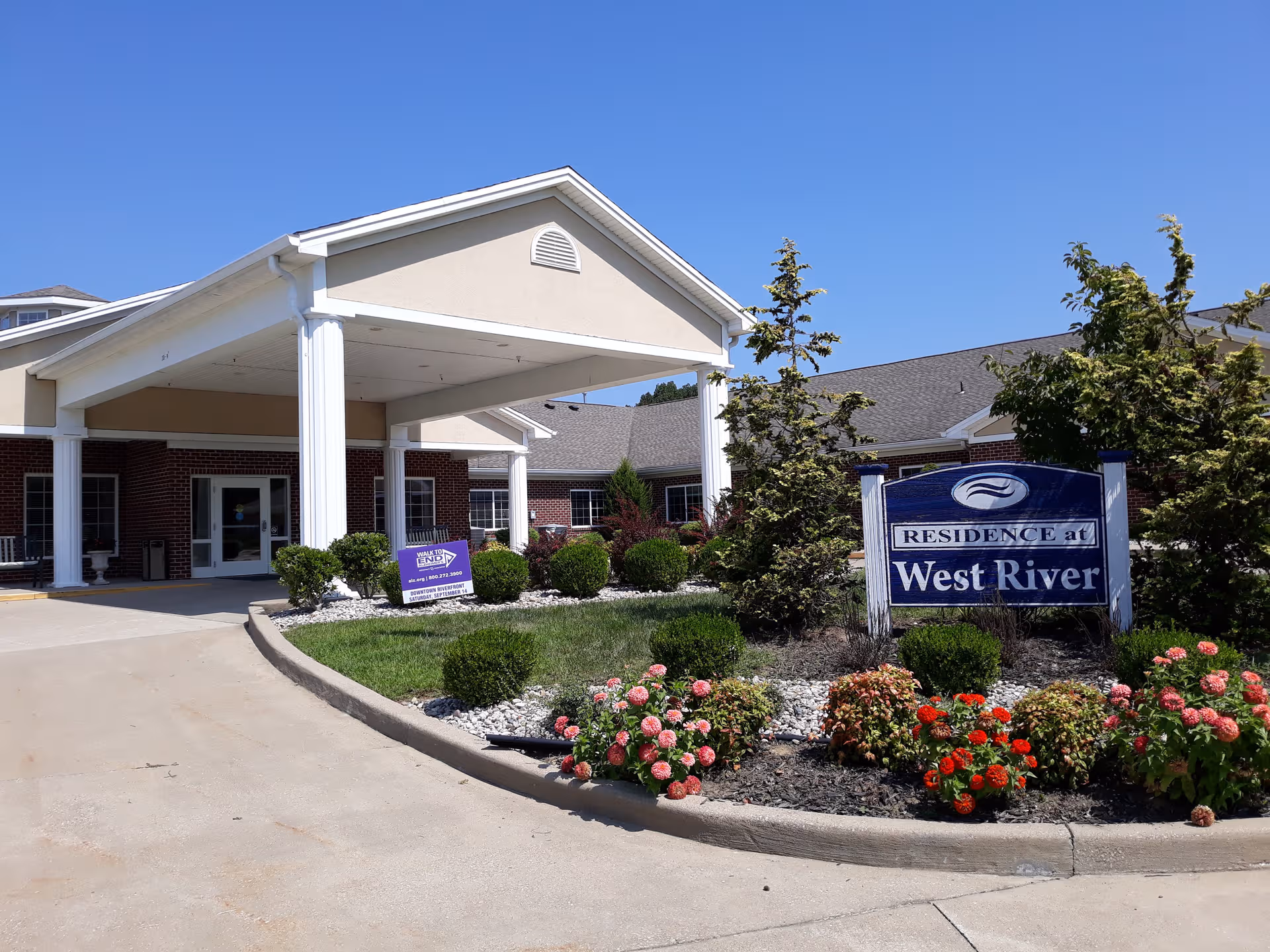 Front exterior view of West River Health Campus with a covered entrance and landscaped flowers.