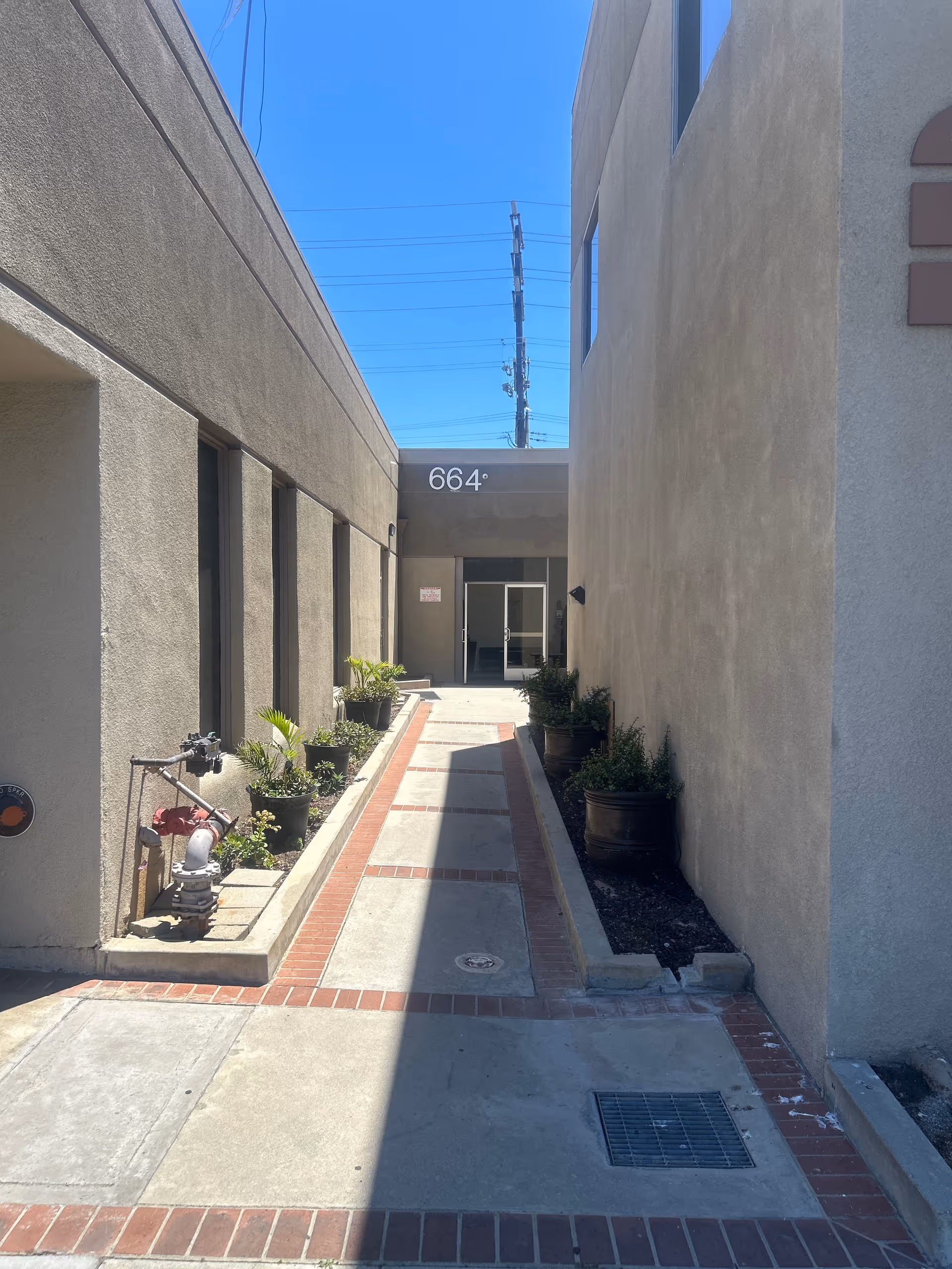 Outdoor corridor at WellNet Home Health with planters along beige walls
