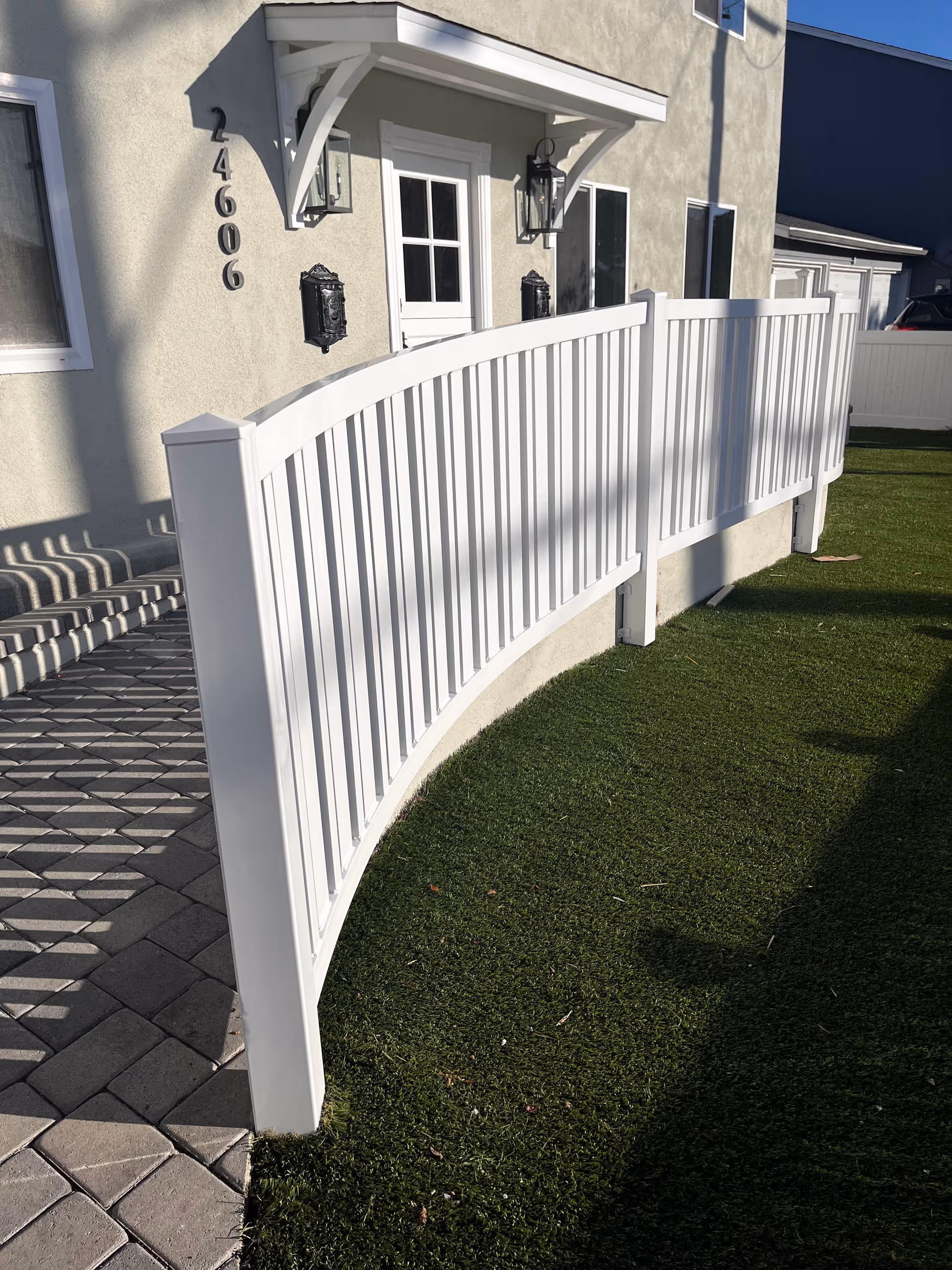 Exterior view of Coral Tree Care Home entrance with a white curved fence and walkway.
