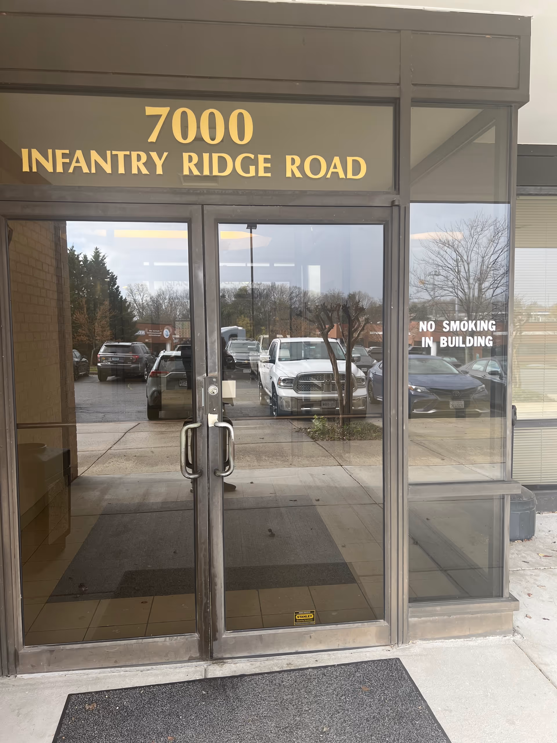 Glass double doors with gold address sign reading 7000 Infantry Ridge Road at entrance