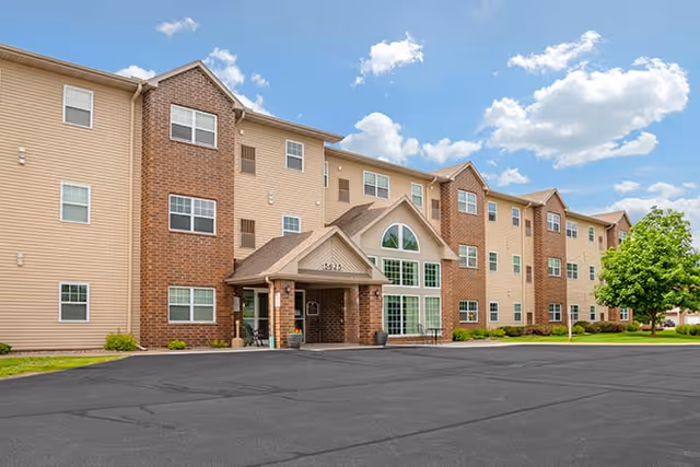 Exterior of Dimensions Living Stevens Point, a three-story senior living building with brick facade.