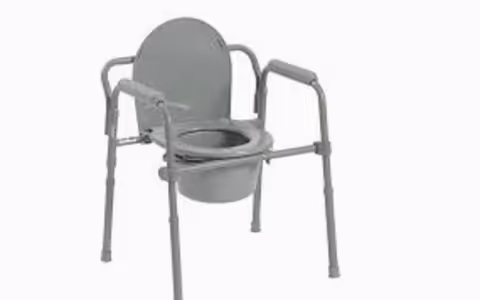 Gray portable commode chair with armrests and waste bucket.