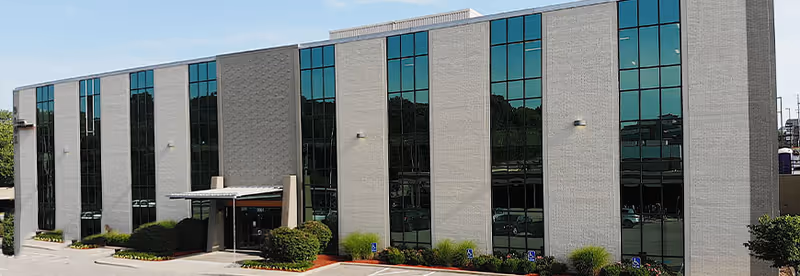 Exterior view of Kansas City Hospice and Palliative Care building with large glass windows.