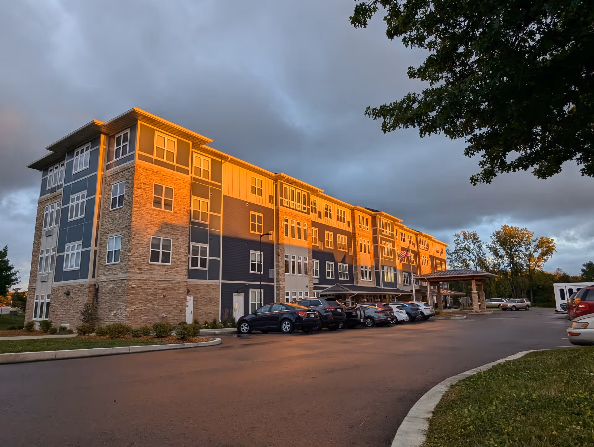Exterior view of Green Oaks of Goshen senior living building with parked cars.