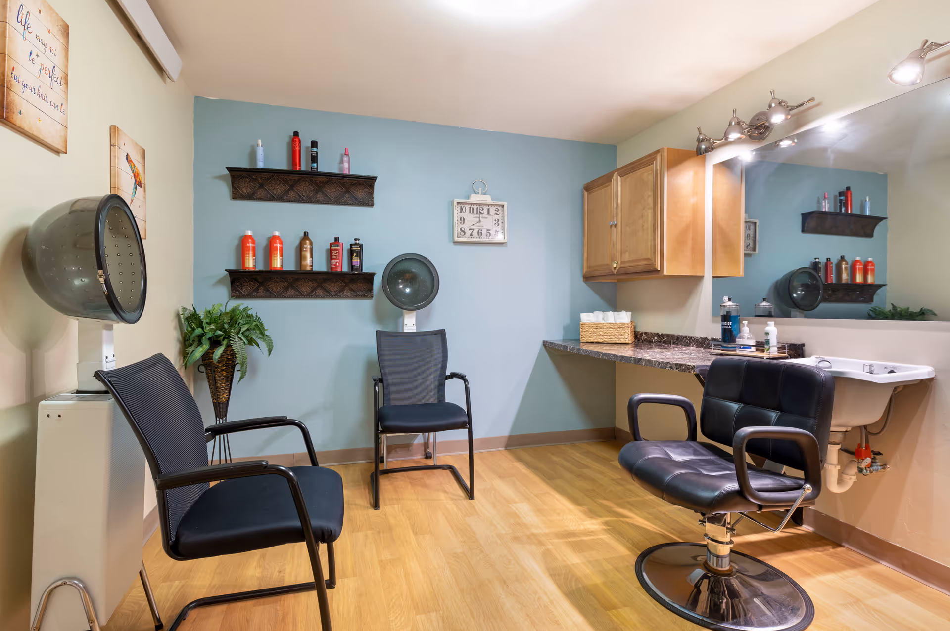 A senior living facility salon with styling chair, sink, mirrors, and product shelves.
