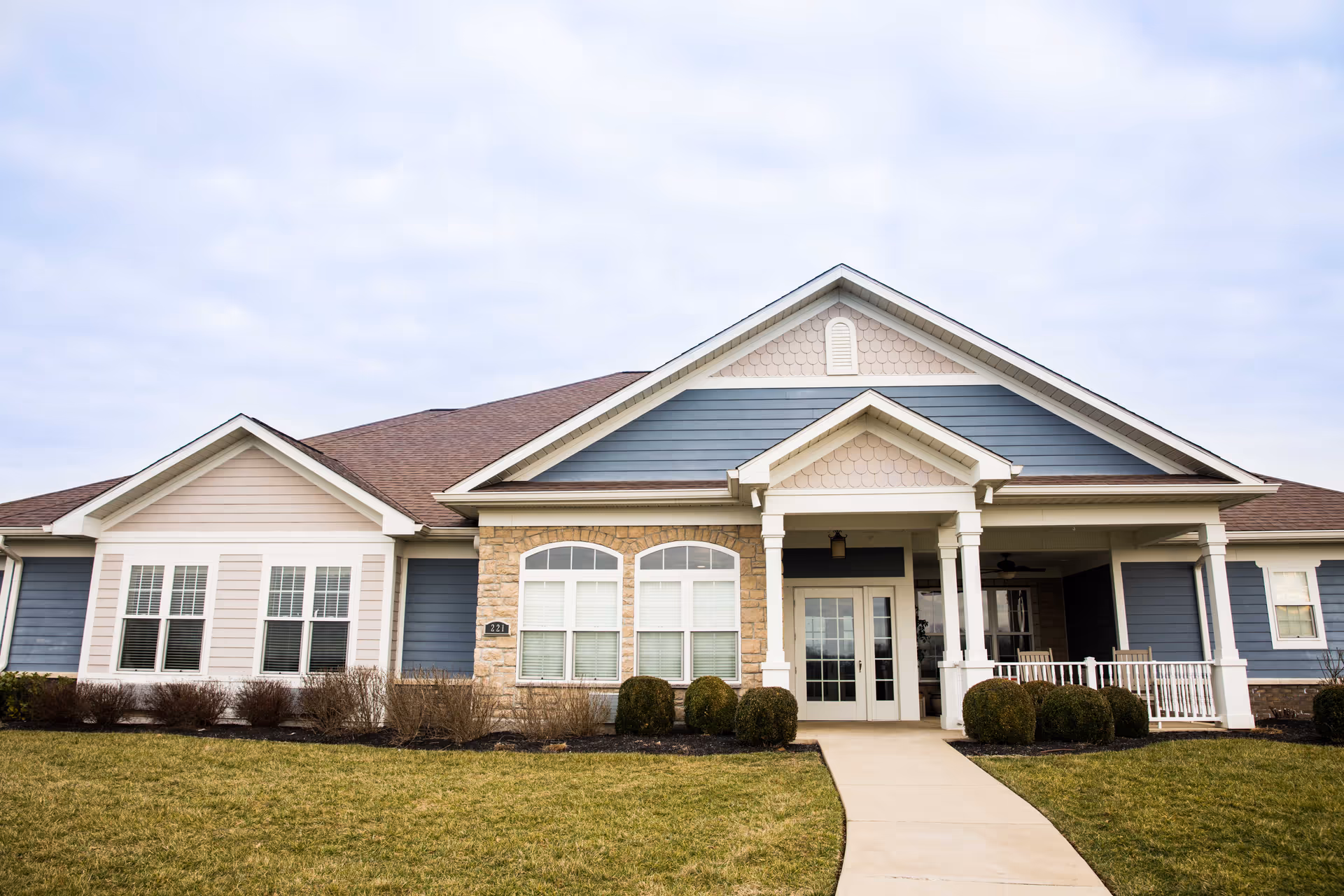 Front exterior of The Homeplace at Midway, a single-story senior living building with a porch.