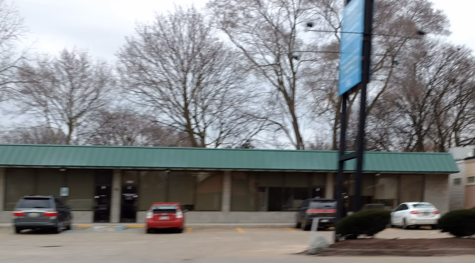 Exterior view of Central Michigan Home Care facility with a green awning and parked cars.