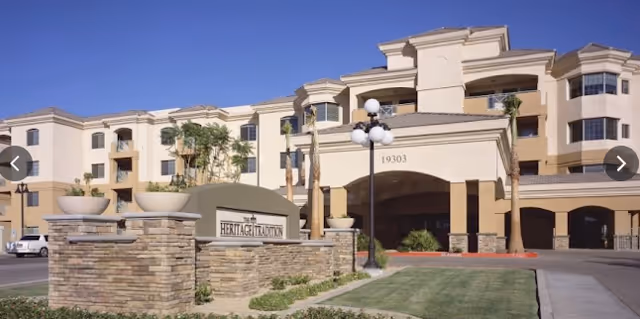 Facade of a multi-story senior living facility, curved entrance, with Heritage Tradition sign.