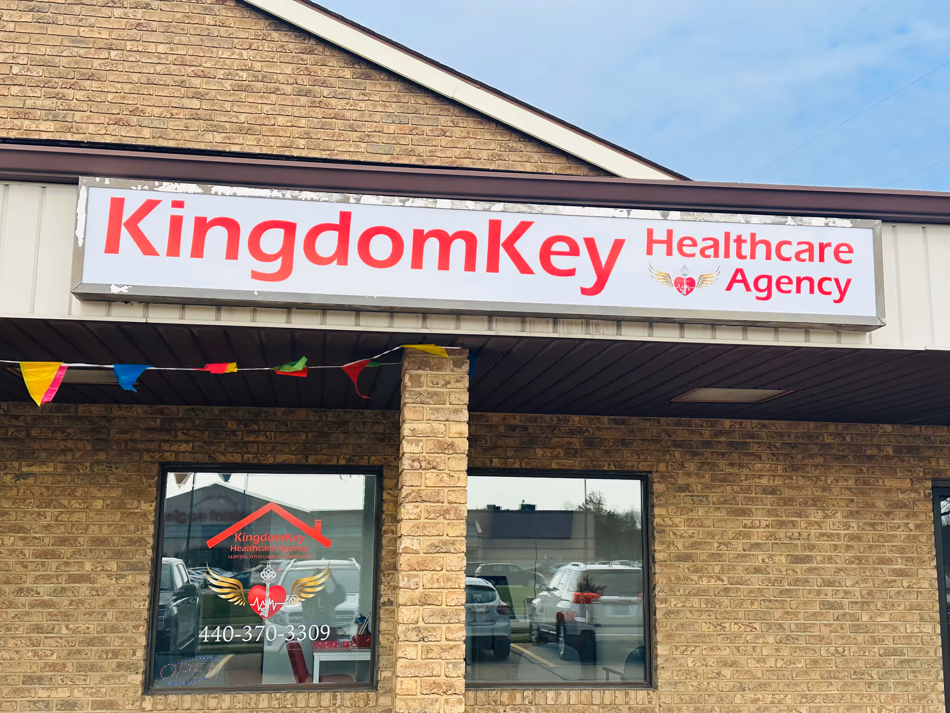 Exterior brick building featuring a large KingdomKey Healthcare Agency sign above windows.