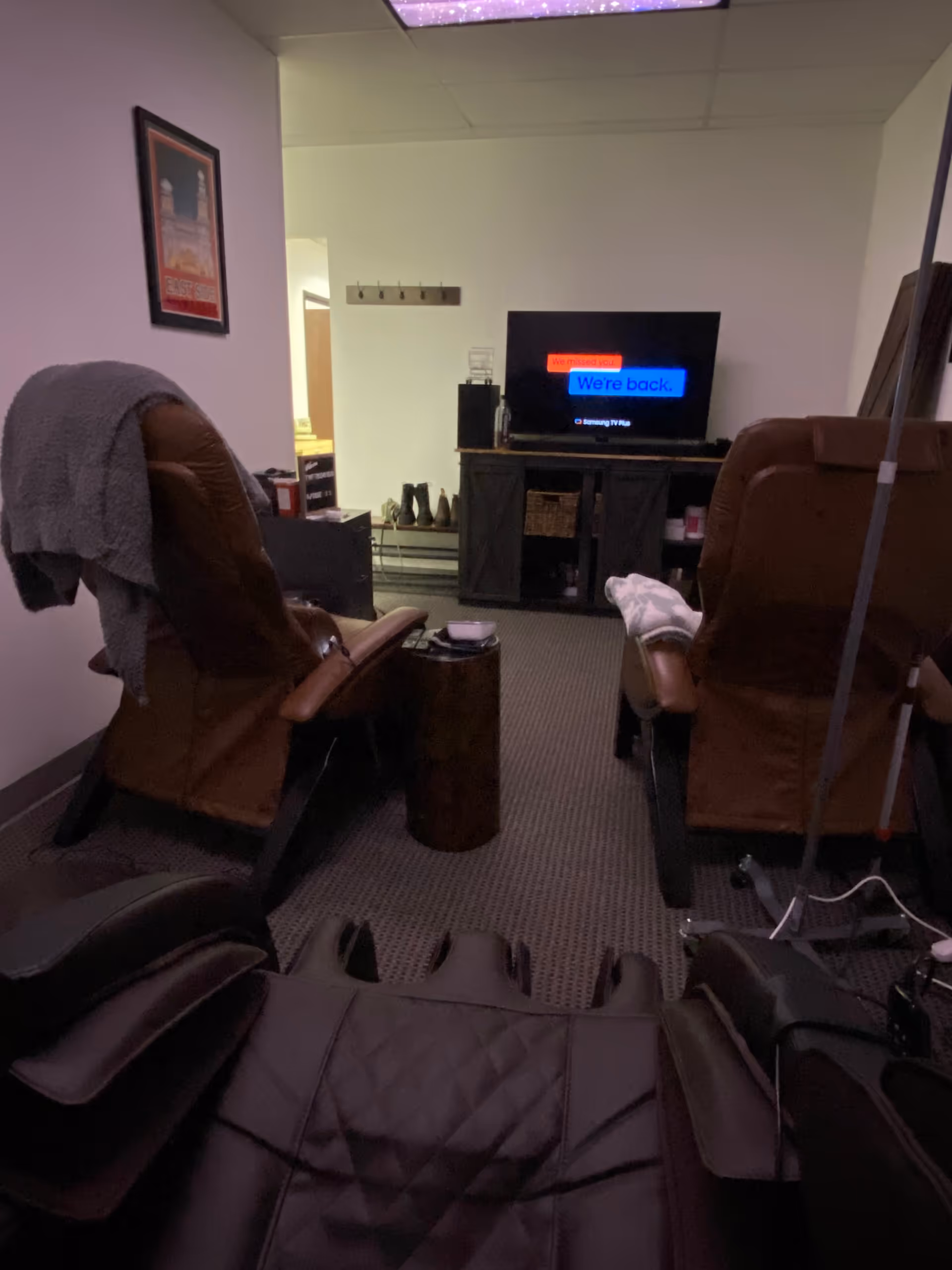 Two reclining chairs facing a TV in a dimly lit senior living room.