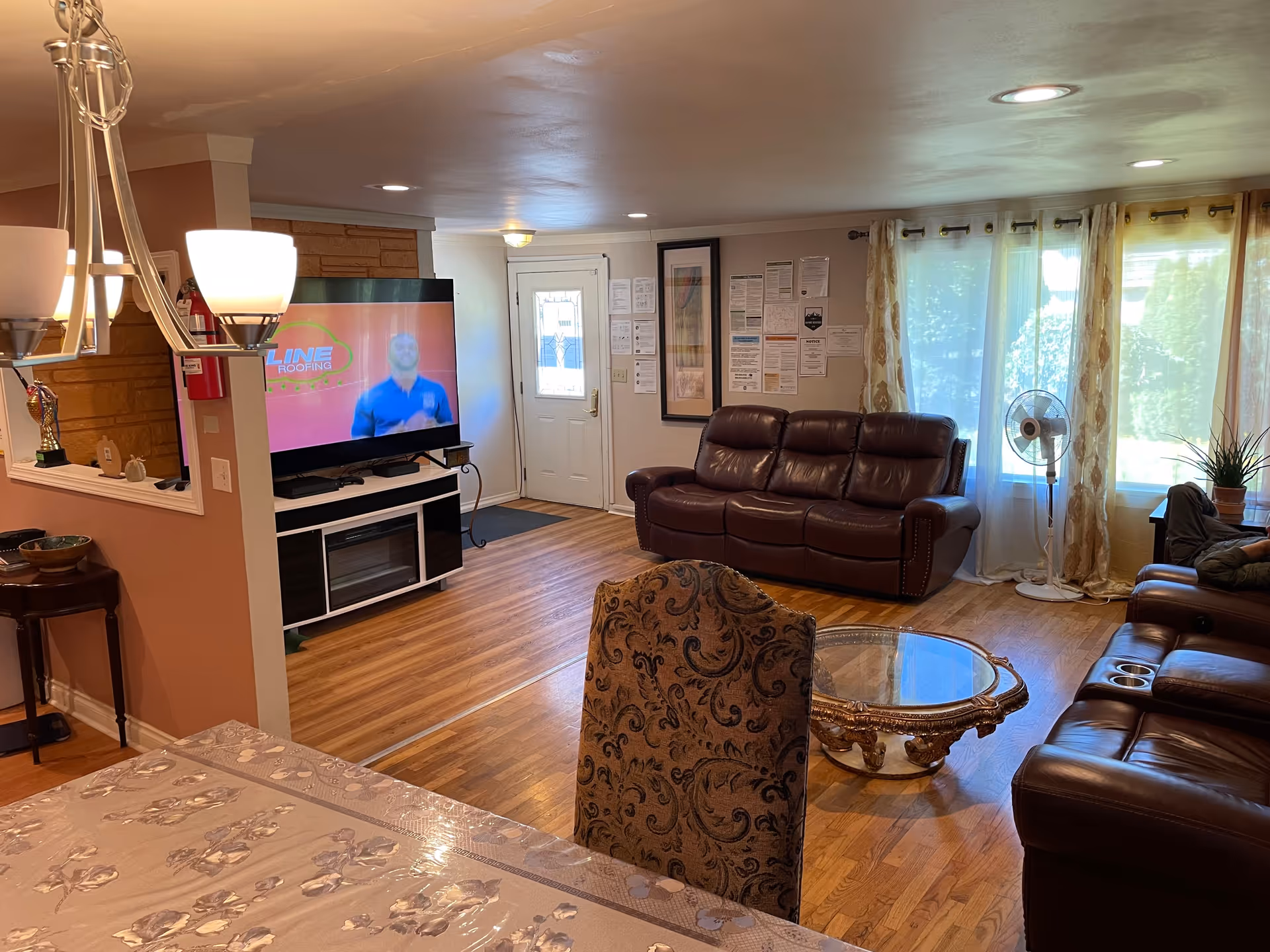 Cozy living room in a senior living facility with leather sofas and a TV.