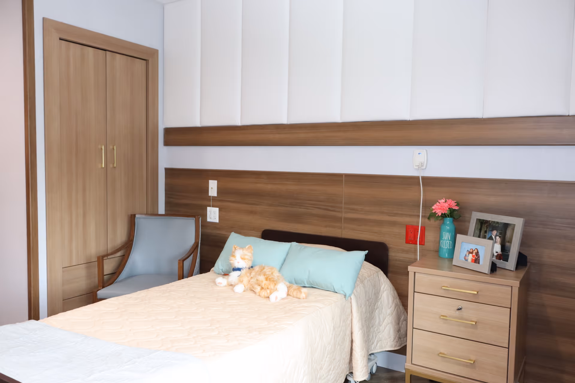 A tidy bedroom at Alaris Health at Riverton with bed, nightstand, and soft decor.