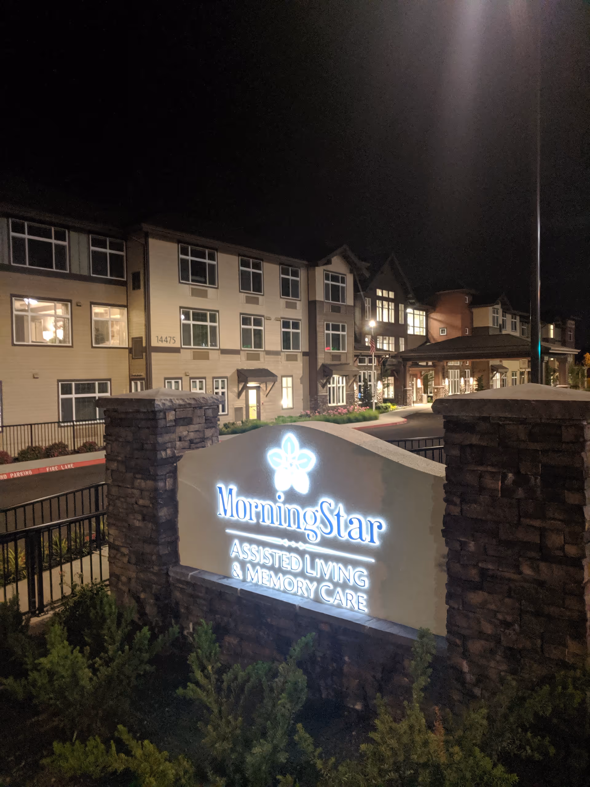 Night exterior of MorningStar assisted living with illuminated sign and building facade.