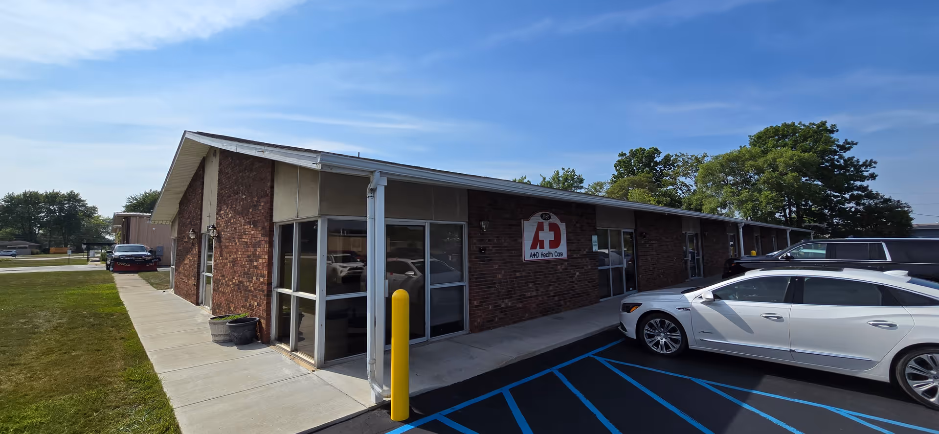 Exterior view of the A&D Home Care & Hospice building with parked cars.