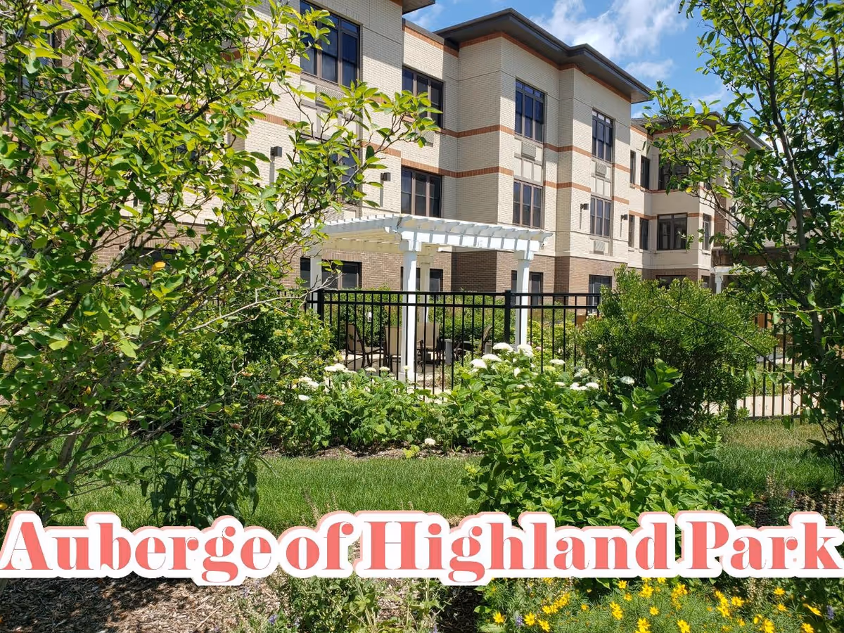 Front view of The Auberge at Highland Park with greenery and a white pergola.