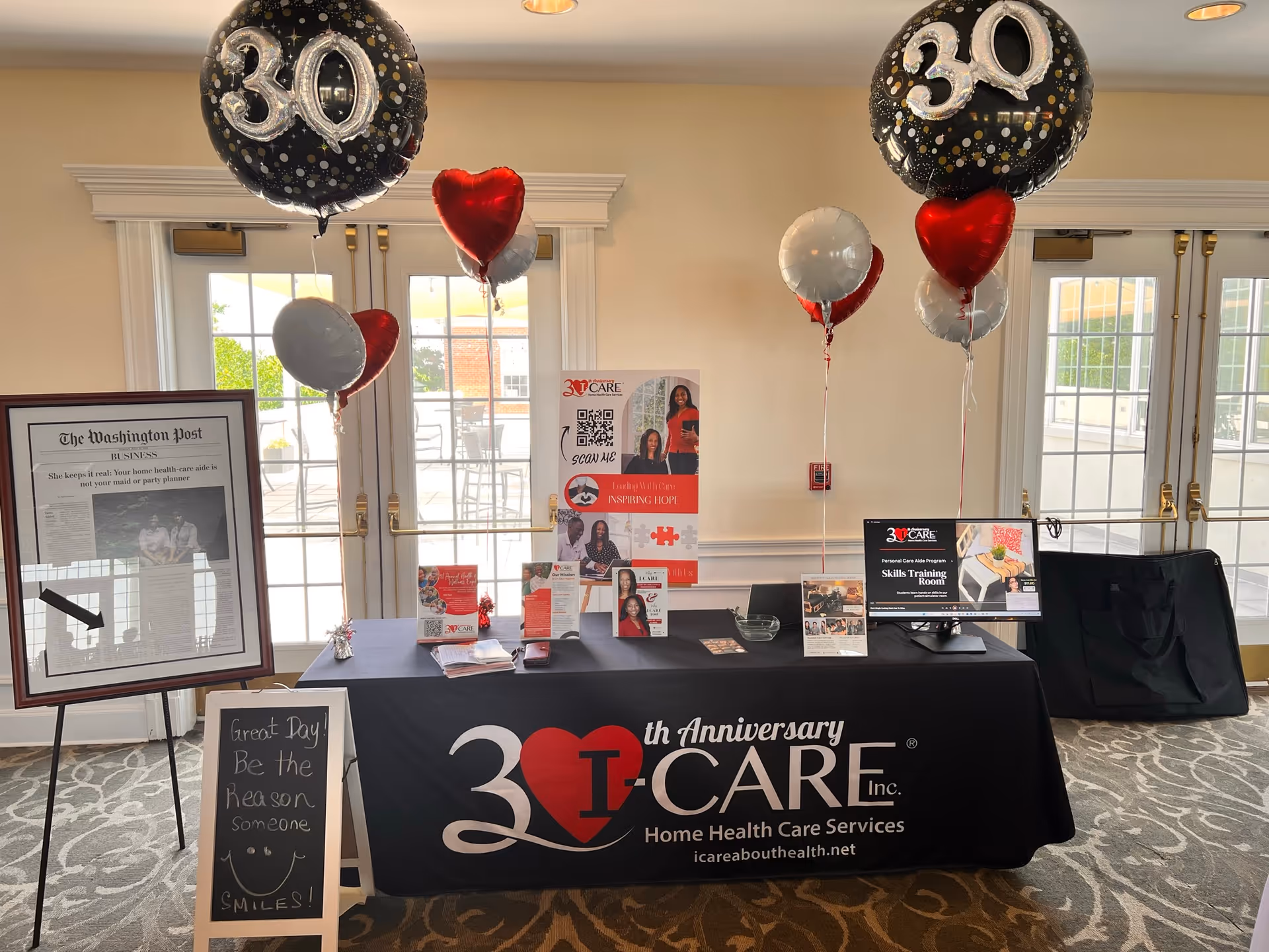 Indoor lobby display with a table, balloons, and promotional materials for I-CARE Home Health Care.
