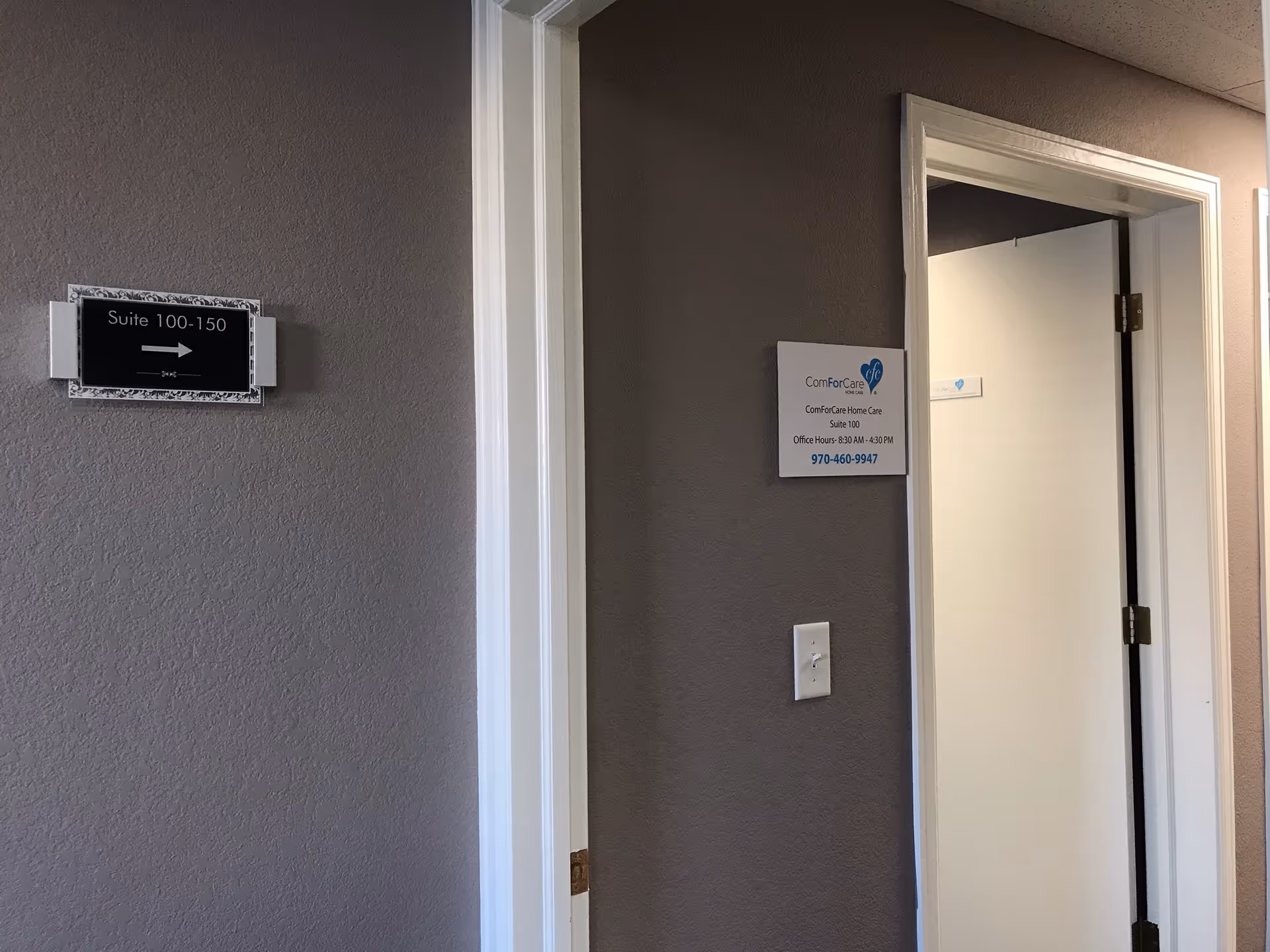 Interior hallway of ComForCare Home Care with doorway, suite sign, and plaque.