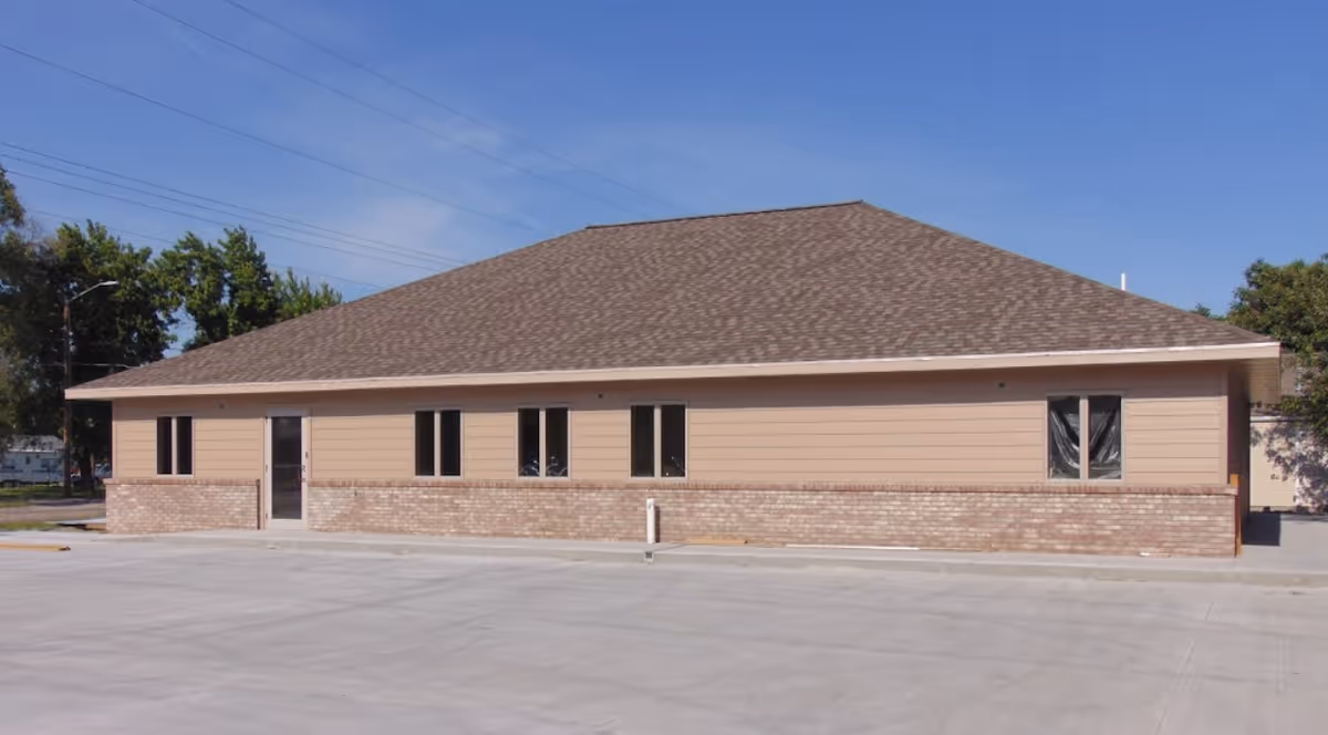 Exterior of a single-story Caretech facility with beige siding and brick base.
