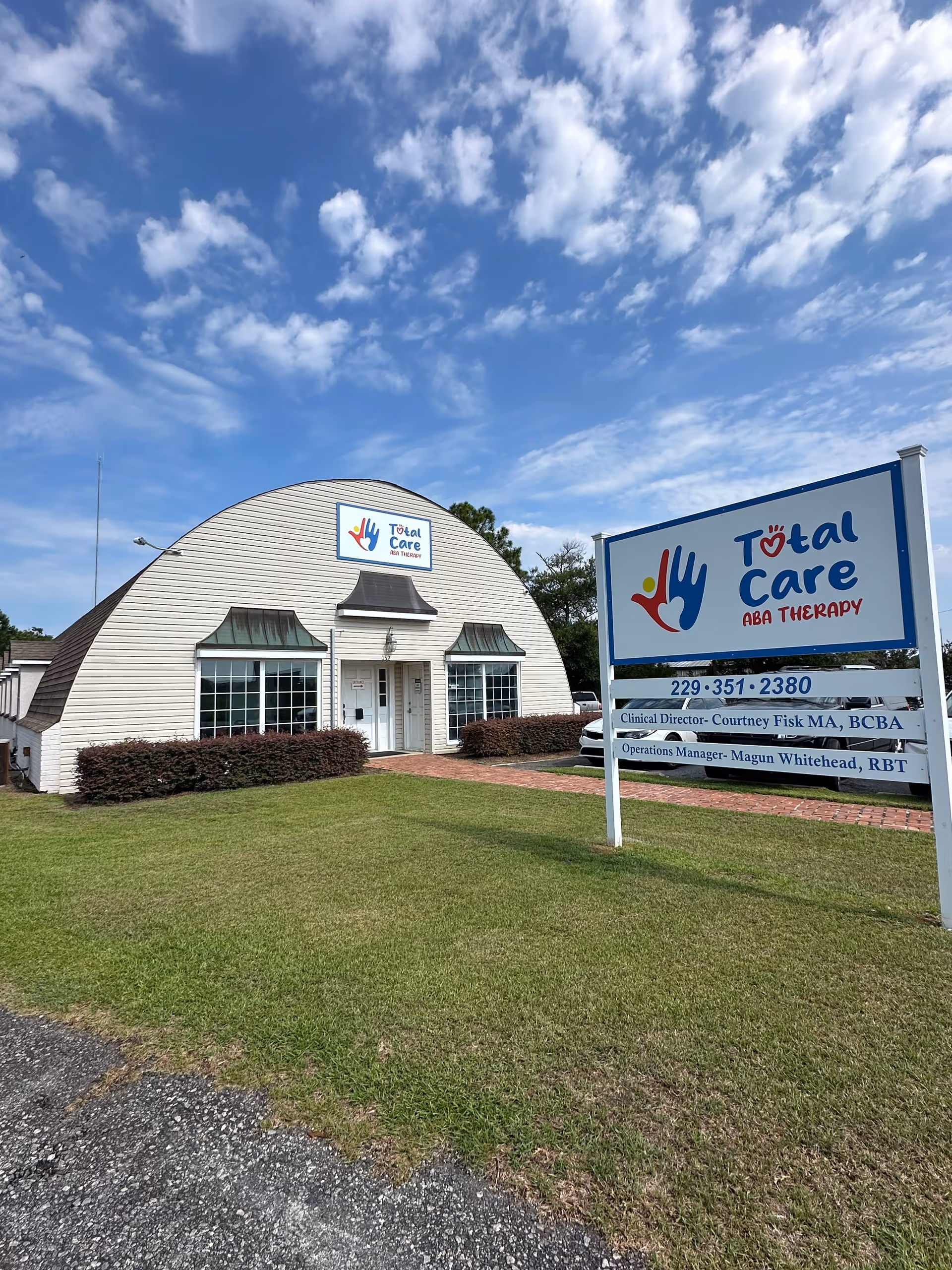 Exterior view of Total Care ABA Therapy building with large front sign on lawn