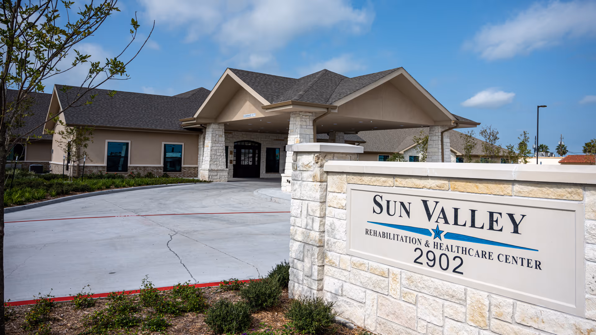 Exterior view of Sun Valley Rehabilitation and Healthcare Center with entrance and sign.