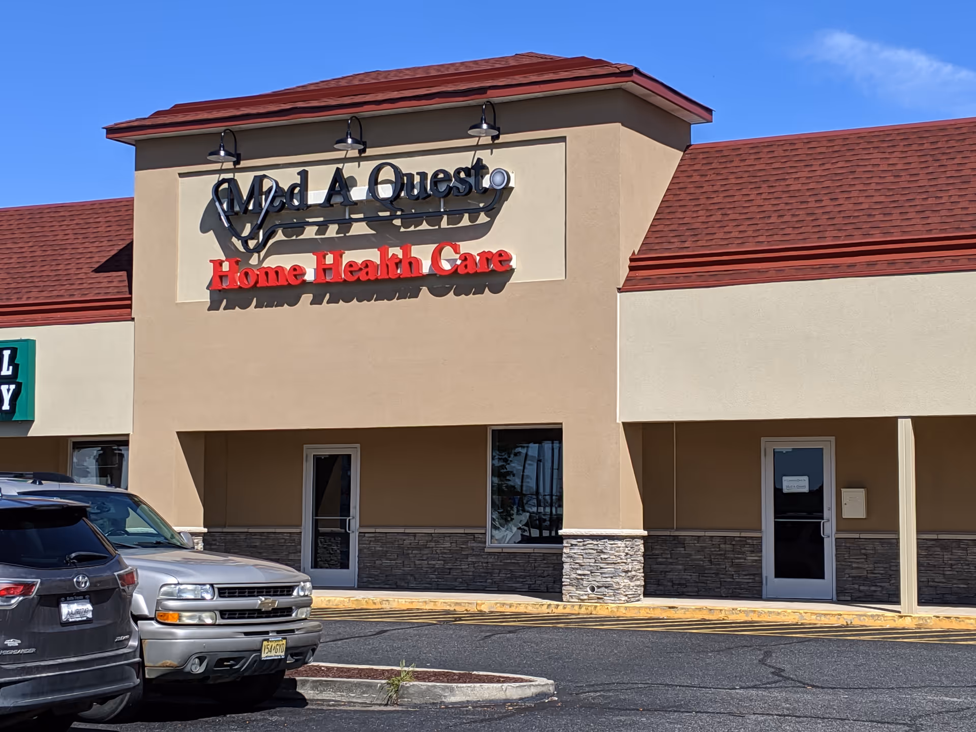 Exterior view of a Med A Quest Home Health Care building with parked cars.