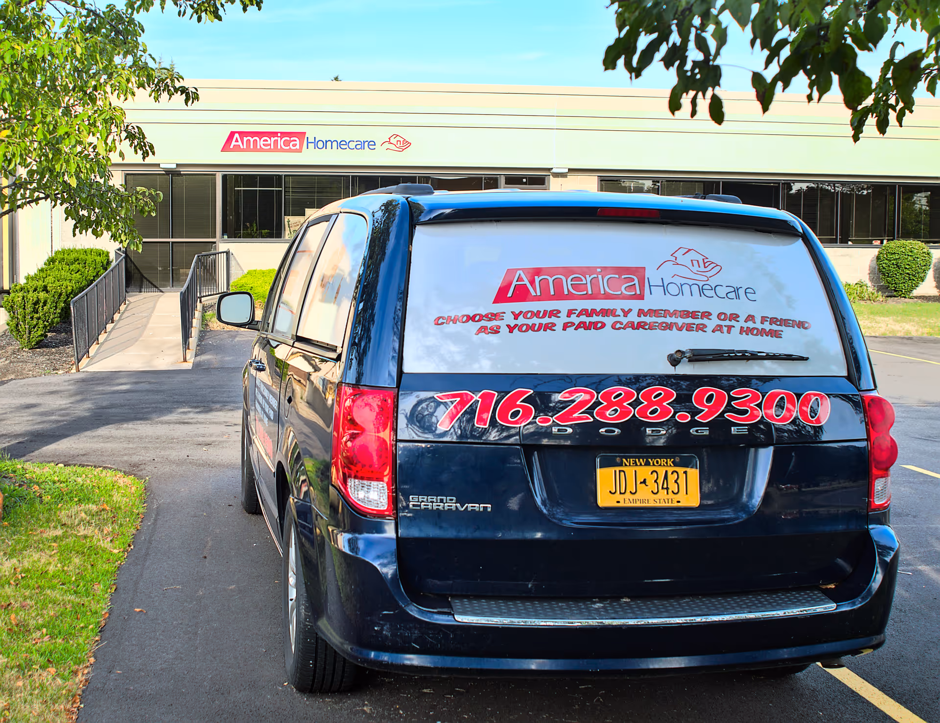 Dark blue van with large red numbers parked in front of America Homecare building.