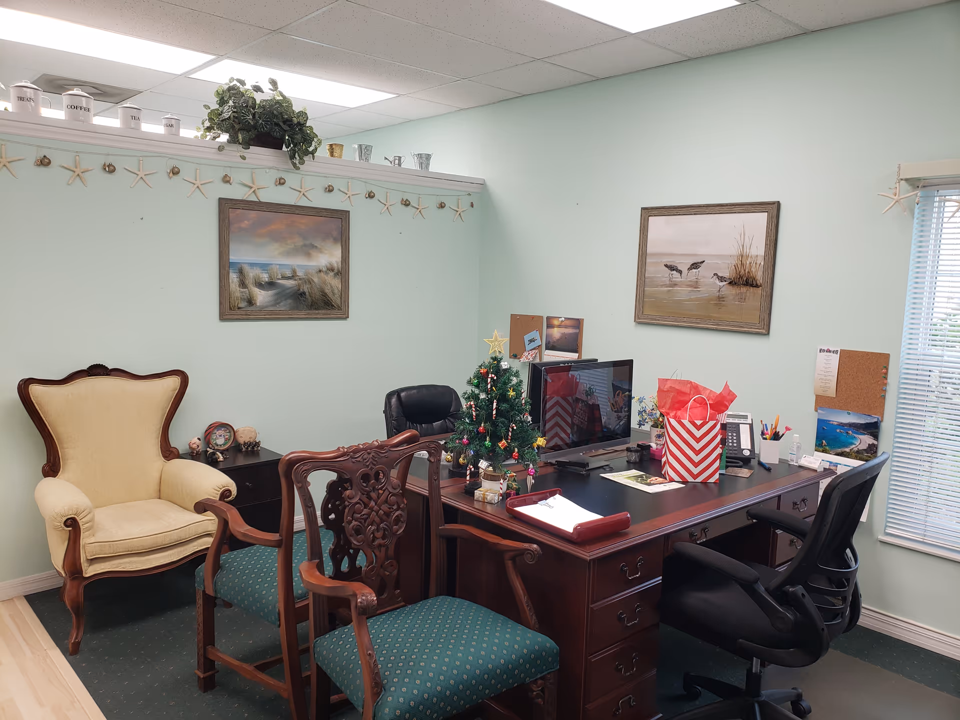 An office workspace in a senior living facility with a large desk, chairs, and decorations.