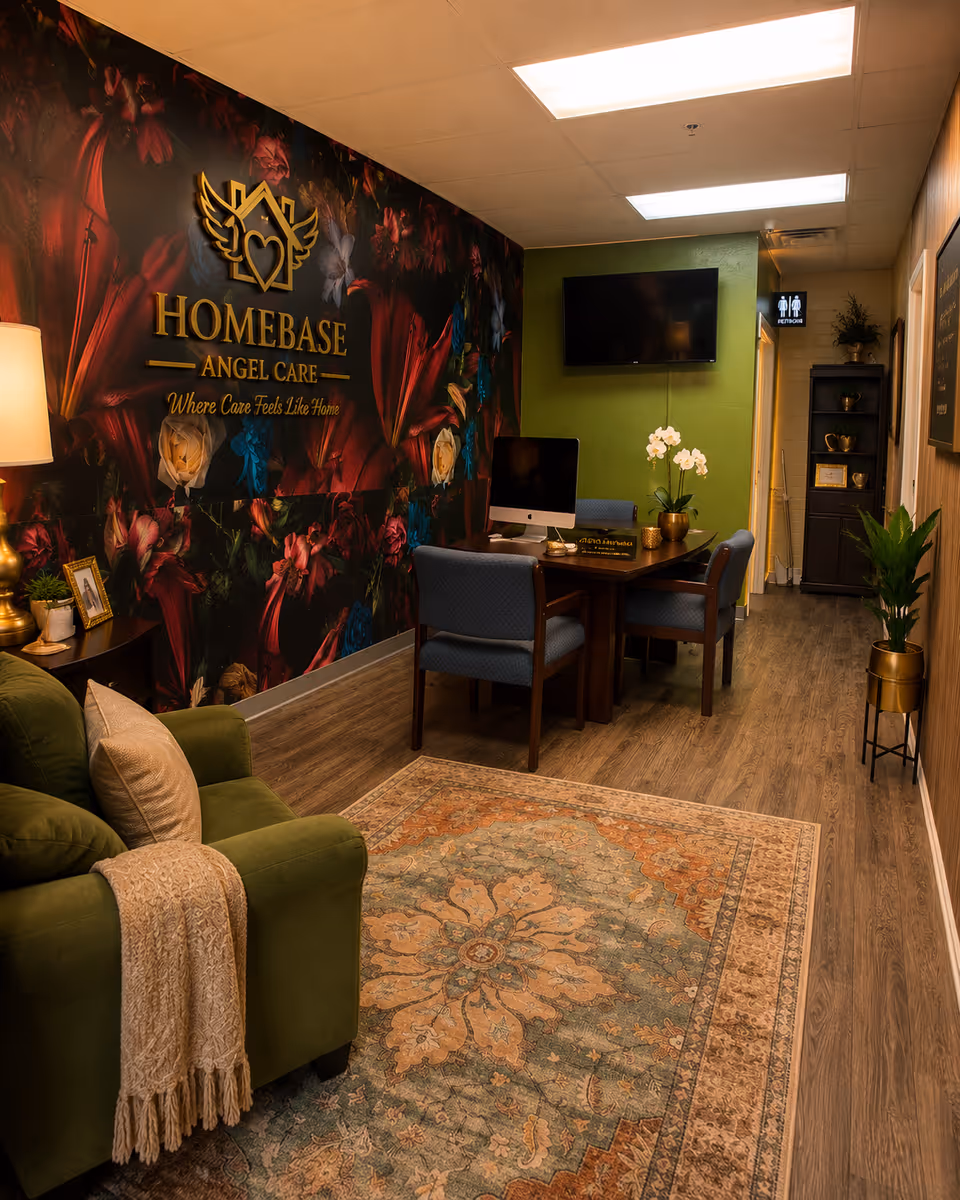Reception area with floral wall, Homebase Angel Care logo, desk, and seating.