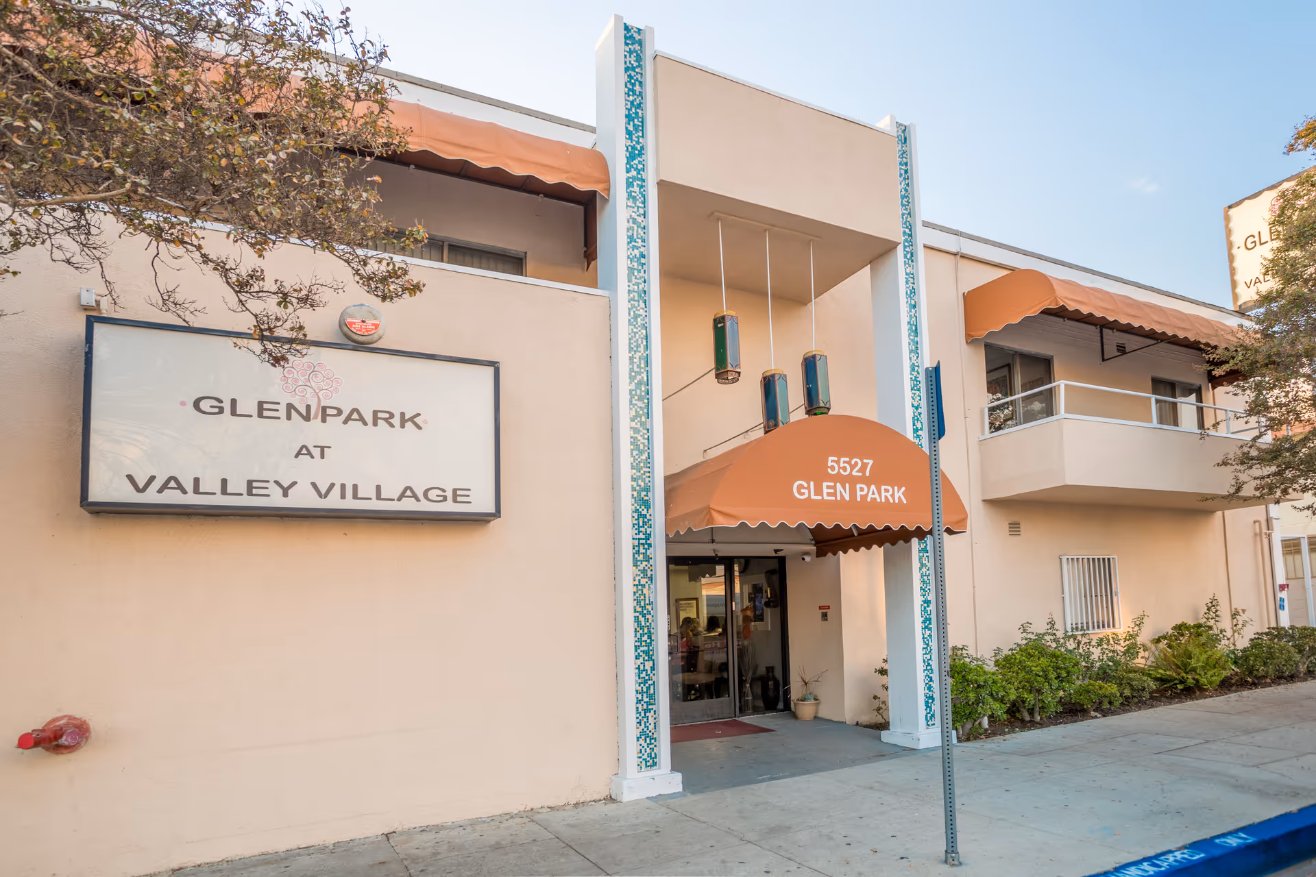 Exterior view of Glen Park at Valley Village entrance with orange awning.