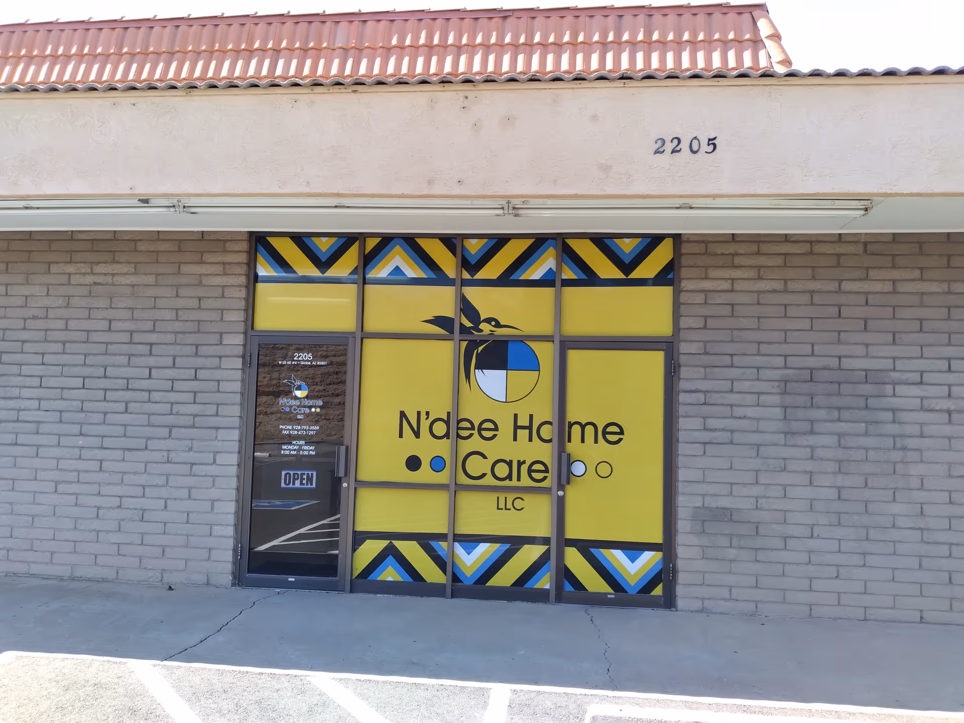 Front entrance of N'dee Home Care LLC with yellow signage on glass.